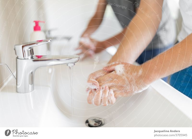 zwei Männer waschen Hände während der Corona Pandemie Händewaschen Hygiene Coronavirus covid-19 Gesundheit Seife Waschbecken Doppelwaschbecken Wasser Wasserhahn