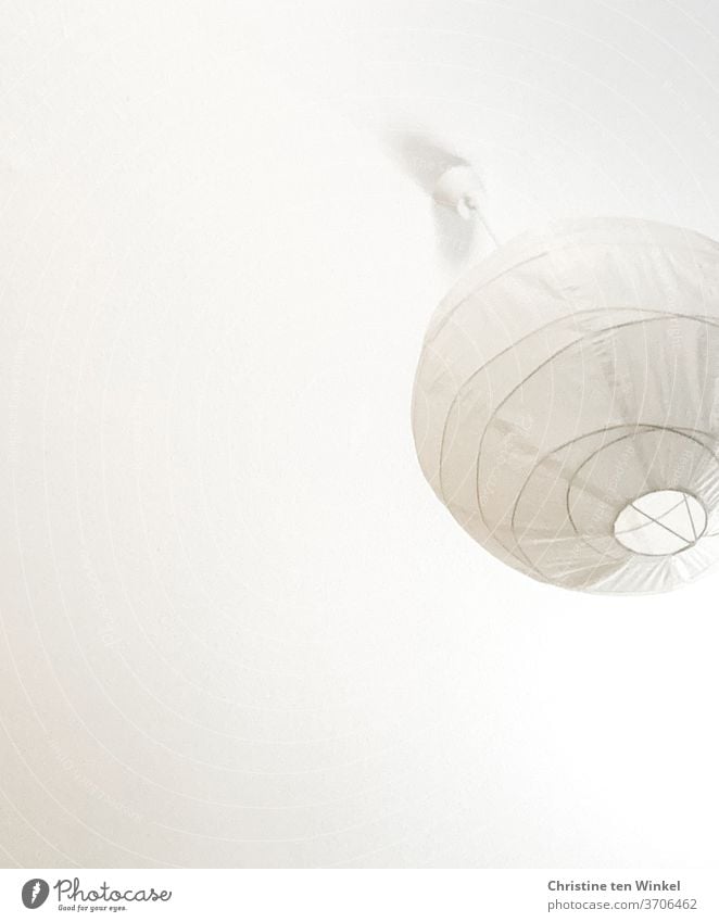 alles weiß... Deckenleuchte aus Papier in Ballonform hängt von einer Zimmerdecke herab. Blick von unten Lampe Papierball Papierlampe Häusliches Leben