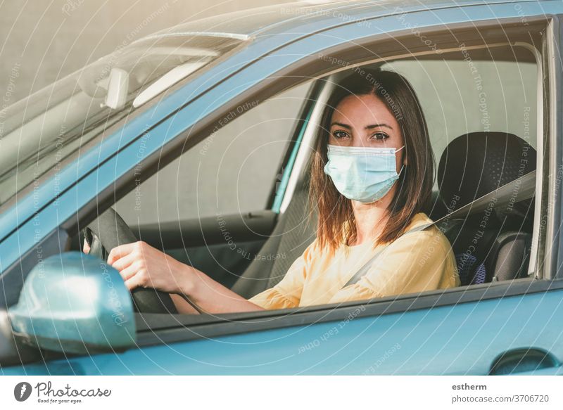 Junge Frau fährt Auto mit medizinischer Maske im Gesicht Coronavirus Virus covid-19 medizinische Maske PKW Laufwerk Sicherheit Ausflug reisen Ausflugsziel