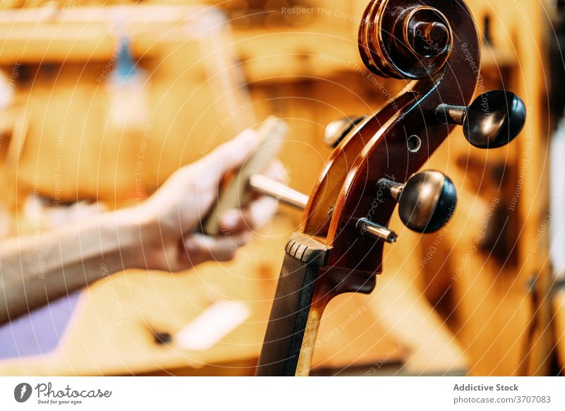 Geigenbauer bei der Arbeit mit Geige in der Werkstatt Zupfinstrumentenmacher Reparatur Reibahle Zapfen Instrument Kunstgewerbler wiederherstellen Mann Handwerk