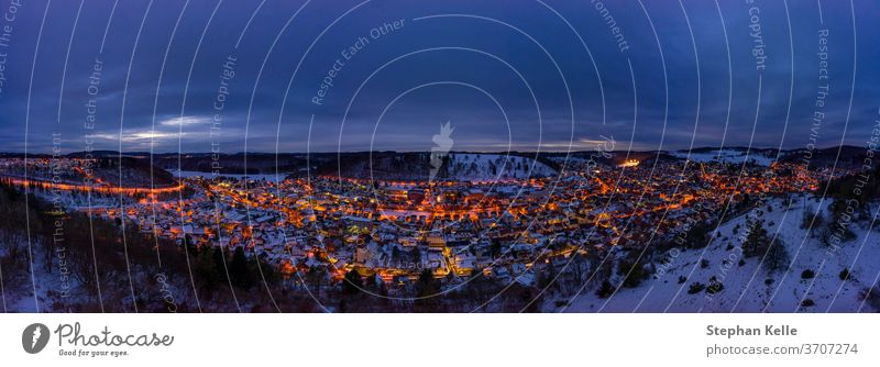 Verschneite Stadtlandschaft der baden-wuerttembergischen Stadt Albstadt in Deutschland zur spaeten Abendstunde mit gluehenden Lichtern. albstadt Winter Schnee