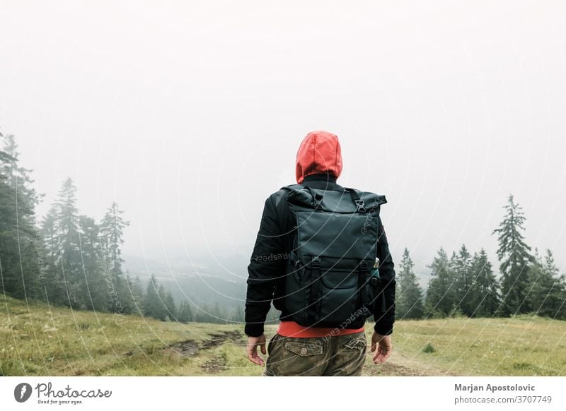 Naturforscher genießt den Blick auf eine neblige Bergkette Abenteuer allein Rucksack Backpacker Umwelt erkunden Entdecker erkundend Nebel Wald Freiheit grün