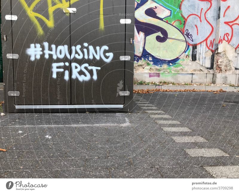 Graffiti mit Hashtag: #HousingFirst / Foto: Alexander Hauk kunst tageslicht außenaufnahmen boden pflastersteine querformat housing housingfirst hashtag