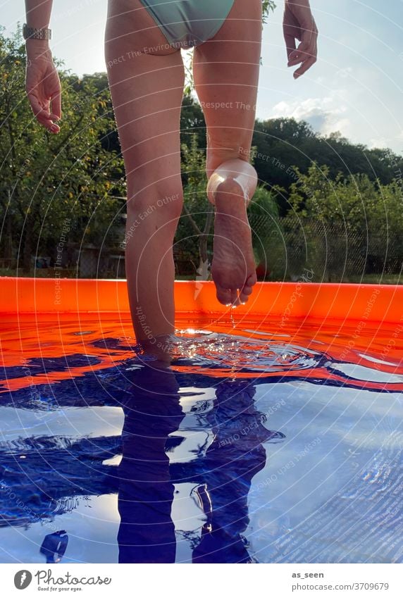 Erfrischung im Gartenpool Planschbecken gehen Wasser Füße orange blau grün Bikini Außenaufnahme Sommer Schwimmen & Baden nass Reflexion & Spiegelung zuhause