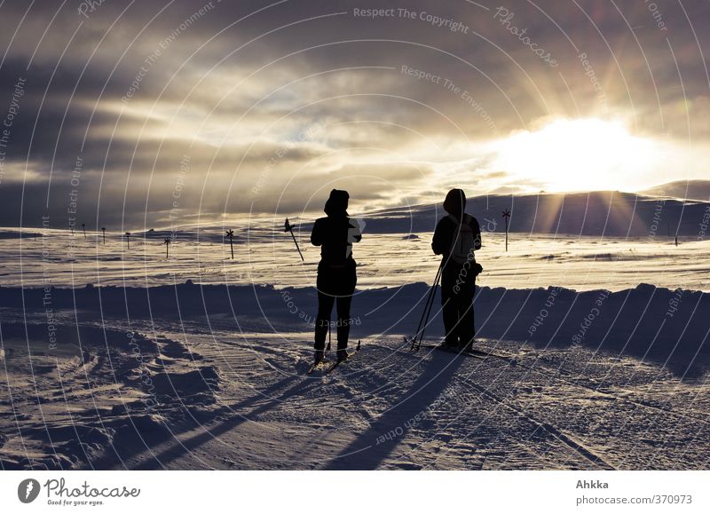 Zwei Menschen in der Sonne vor abendlicher Winterlandschaft exotisch harmonisch Wohlgefühl ruhig Abenteuer Freiheit Expedition Schnee Berge u. Gebirge Natur