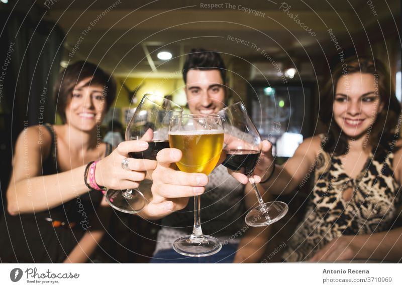 Drei Freunde im Restaurant mit Alkoholbechern, die auf die Aussicht anstoßen Bar Zuprosten Getränke Erwachsene Kaukasier Bier Wein trinken Essen Frauen
