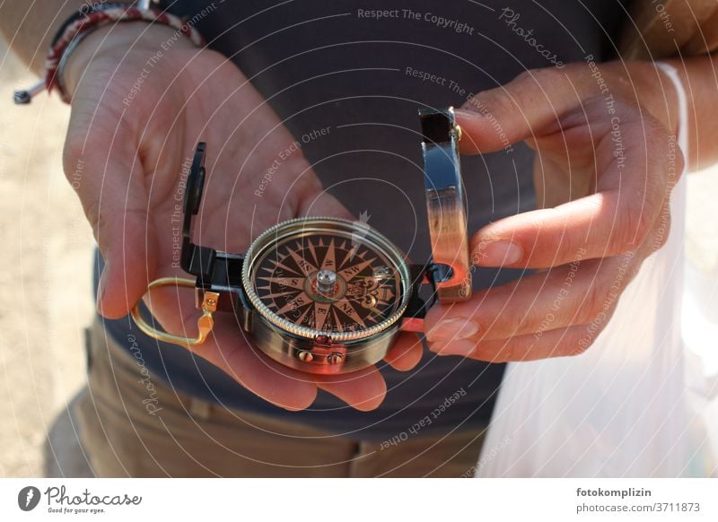 zwei Hände halten einen kleinen Kompass Richtung richtungsweisend Richtungswechsel Orientierung Navigation Himmelsrichtung Wegweiser Hinweis Empfehlung zeigen