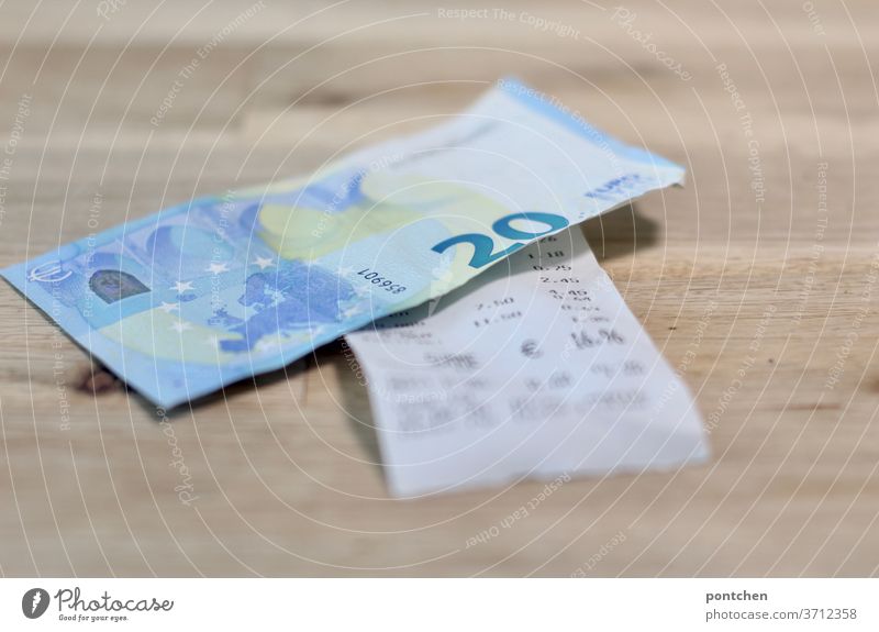 Ein 20 Euro Schein liegt auf einer Rechnung. Bezahlen, Trinkgeld Geldschein kassenbon trinkgeld bezahlen Kapitalwirtschaft Bargeld Business Wirtschaft