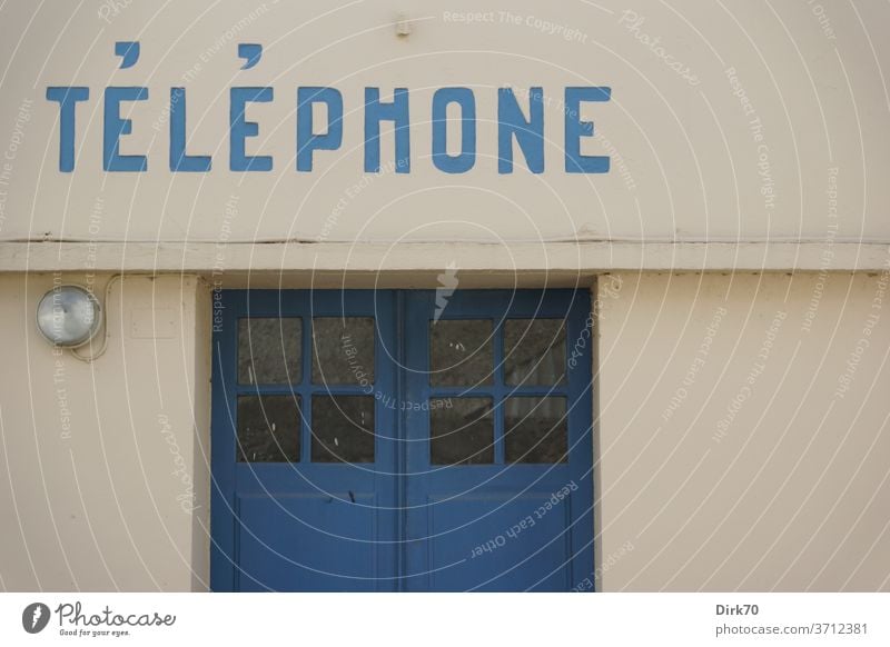 Öffentliches Telefon in der Bretagne Kommunikation Telefonzelle öffentliches telefon Tür Lampe Fassade Gebäude Haus Schrift Telekommunikation Farbfoto
