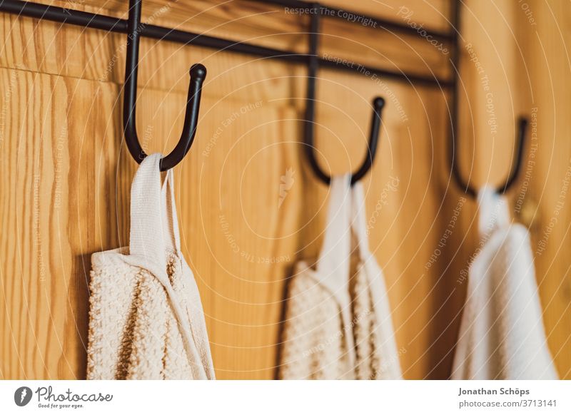 weiße Handtücher am Haken an einer Holztür Bad Badezimmer Ferienwohnung Handtuchhaken Hotel Innenaufnahme Trocknen Tür Wohnung Zuhause aufhängen ordentlich