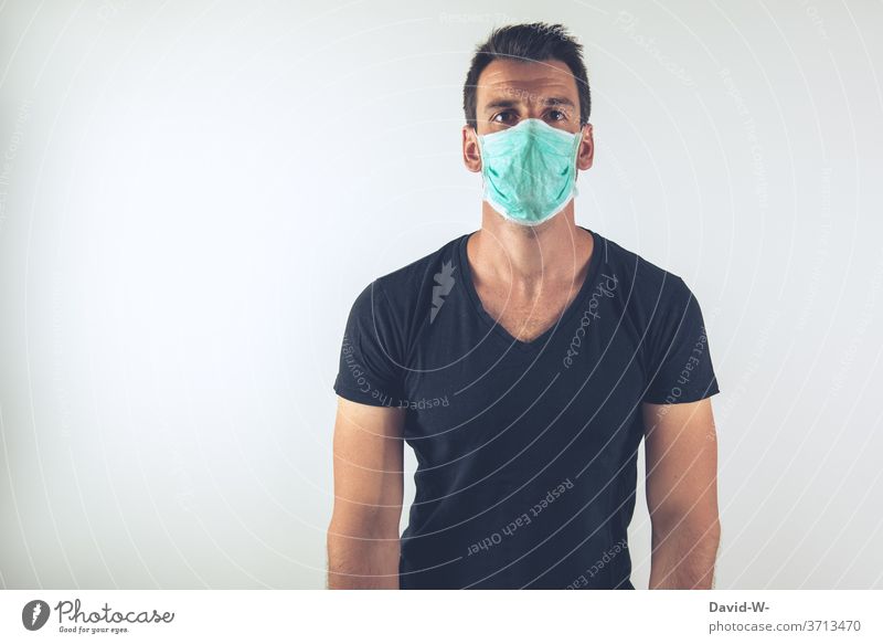 junger Mann mit Atemschutzmaske schaut in die Kamera Corona Coronavirus Pandemie Maske authentisch echt Geduld verlieren Mundschutz Virus Krankheit Gesundheit