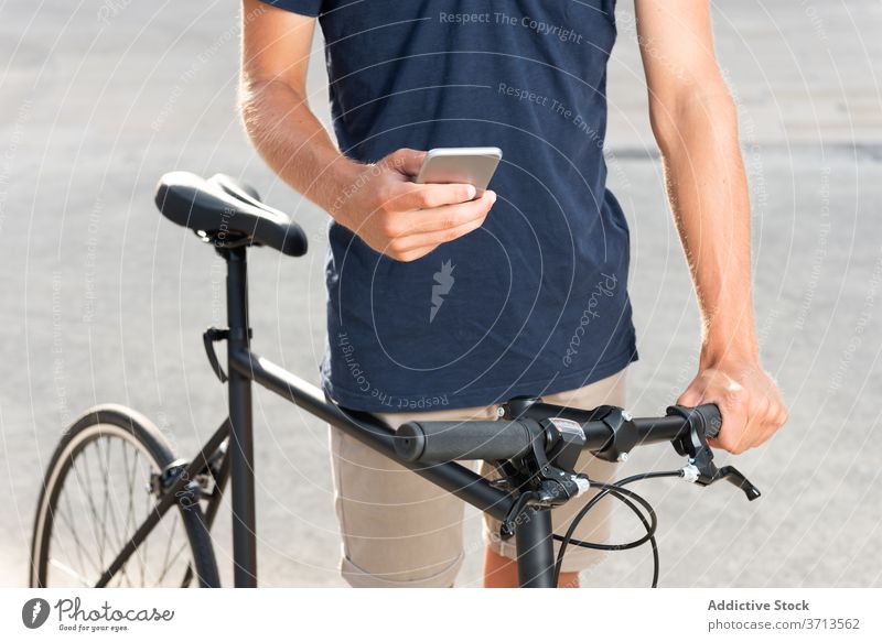 Mann zu Fuß mit Fahrrad, während auf dem Mobiltelefon blond Business lässig Kaukasier Funktelefon Mitteilung Fahrradfahren Radfahrer freiberuflich Apparatur