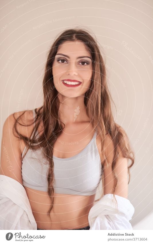 Lächelndes junges Modell mit frischem eleganten Make-up Frau Kosmetik modern heiter Inhalt feminin ethnisch brünett lange Haare rote Lippen professionell