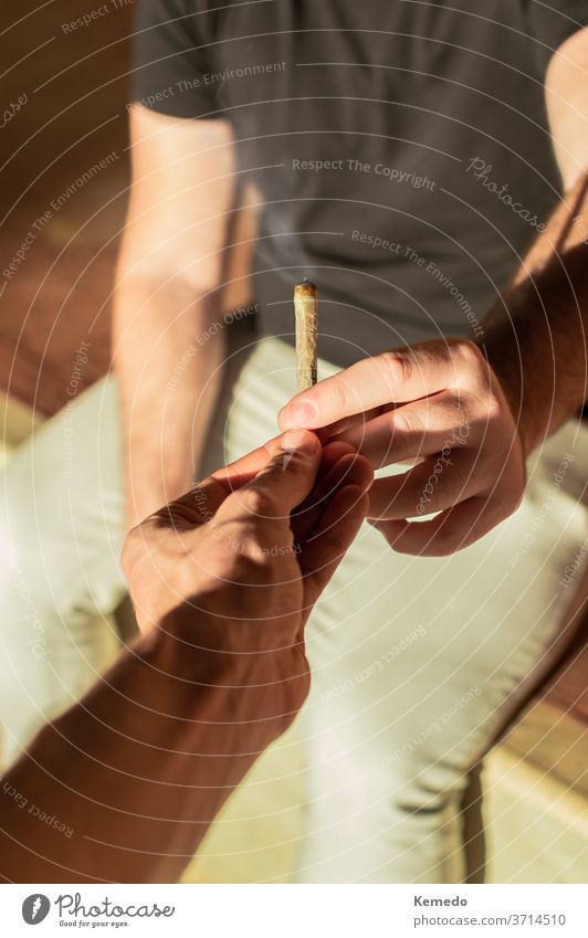 Jugendliche, die sich an einem sonnigen Nachmittag einen Cannabis-Joint teilen. Gelenk Topf Marihuana Rauch Teilen Freunde männlich Mann Junge Jungs Außenseite
