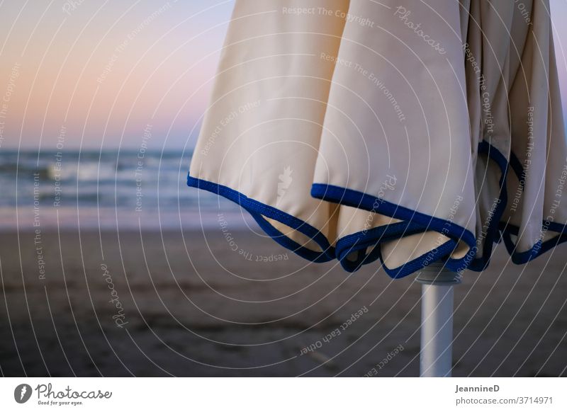 geschlossener Sonnenschirm mit Abendstimmung blau Ferien & Urlaub & Reisen Meer Erholung Sommerurlaub Strand Außenaufnahme Menschenleer Sonnenbad Tourismus