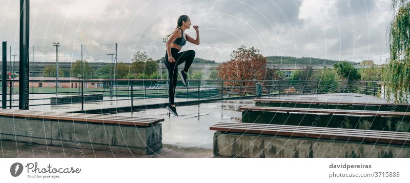 Mädchen springt beim Training auf Bänke regnerisch Sport springend Energie Ermächtigung Stil Körper Boxerflechten Fitness passen Transparente Netz panoramisch