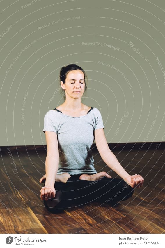 Frau sitzt im Schneidersitz auf dem Boden und macht Yoga-Entspannungsübungen. trainiert. Menschen meditierend Sitzen Frauen Flexibilität Gleichgewicht