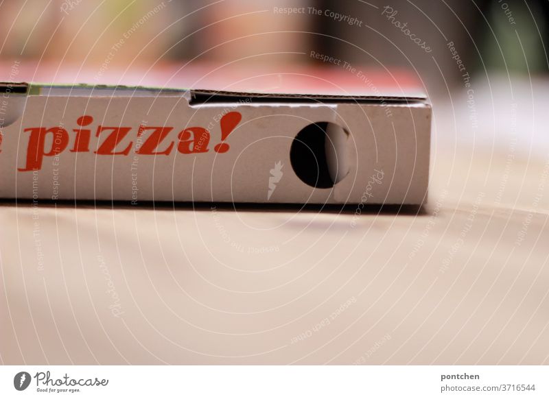 Das Wort Pizza steht auf einem Karton. Pizzakarton. Lieferdienst, Lieferservice lieferdienst pizzakarton zum mitnehmen bequemlichkeit essen bestellen tisch