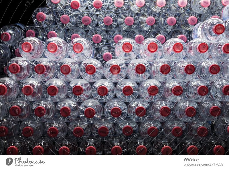 Viele Wasserflaschen liegen gestapelt in einem Kühlschrank zum Verkauf PET-Flasche Trinkwasser kühl viele kalt Kühlung Plastikflasche Deckel Beleuchtung Getränk