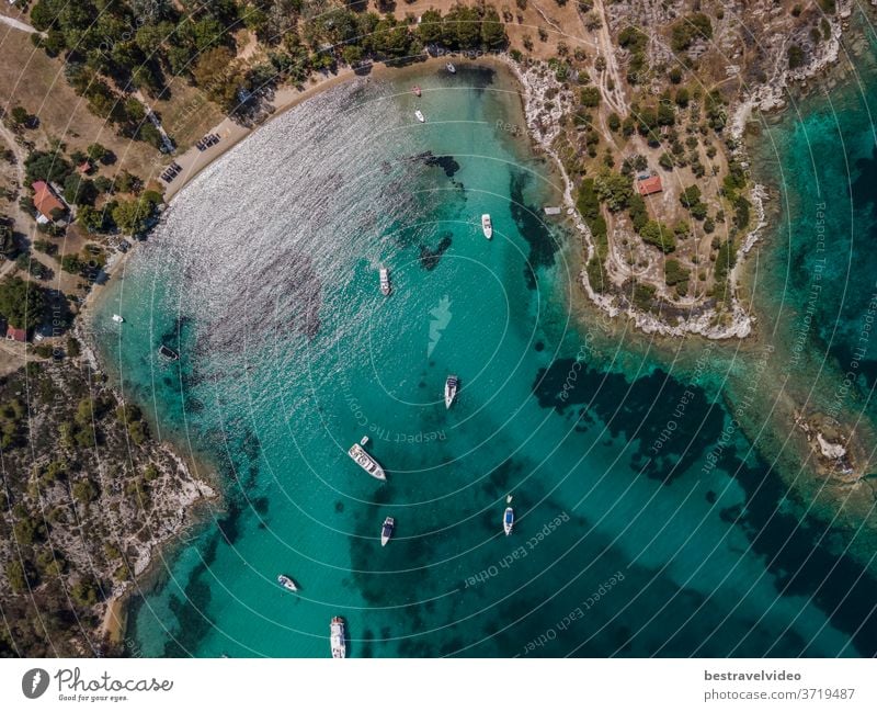 Mediterrane griechische Landschaftsdrohne mit vertäuten Freizeitbooten beschossen. Luftaufnahme der Halbinsel Sithonia Chalkidiki aus der Vogelperspektive über der Küste mit grüner Plantage und kristallklarem, ruhigem Meer.