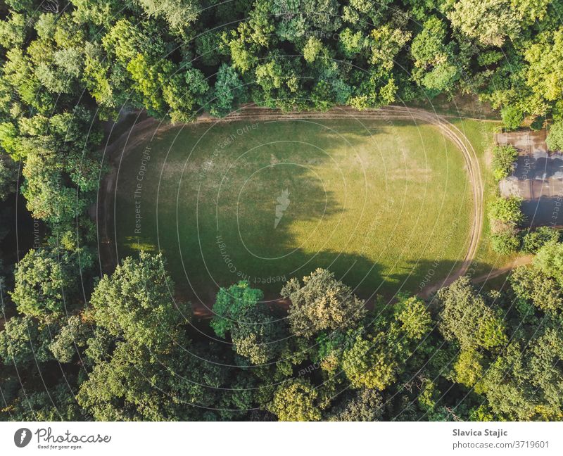 Luftaufnahme eines leeren Feldes mit Trimmpfad in einem dichten Wald oben Antenne Hintergrund Gericht Gerichte Tag Design Übungen Fitness Laubwerk Fußball