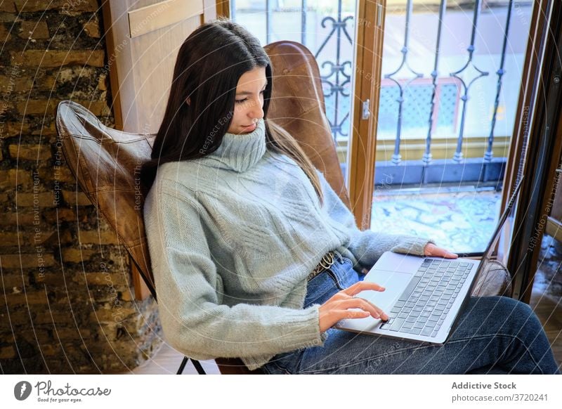 Frau arbeitet am Laptop zu Hause freiberuflich abgelegen Arbeit Tippen Projekt Surfen benutzend Inbetriebnahme heimwärts gemütlich Armsessel Internet Apparatur