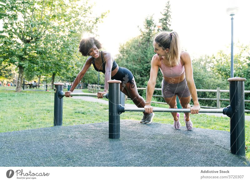 Sportliche Frauen machen Liegestütze im Park Fitness Training hochschieben heiter Zusammensein Übung sportlich Freund jung rassenübergreifend multiethnisch