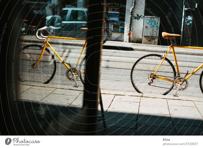 Gelbes vintage Rennrad steht auf der Straße vor einem Geschäft gelb Fahrrad Fahrradfahren retro Sattel Ledersattel Sport Lifestyle trendy Mobilität hip Schloss