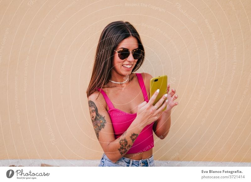 schöne junge Frau im Freien mit dem Mobiltelefon. Technologie und Lebensstil Handy Straße urban Lifestyle Lächeln Großstadt Technik & Technologie Tattoo modern