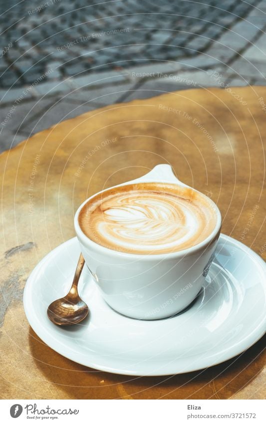 Eine Tasse Cappuccino auf einem goldenen Tisch im Café Kaffee Latte Art Koffein Getränk Kaffeetrinken Kaffeepause lecker warm Kaffeetasse Heißgetränk Löffel