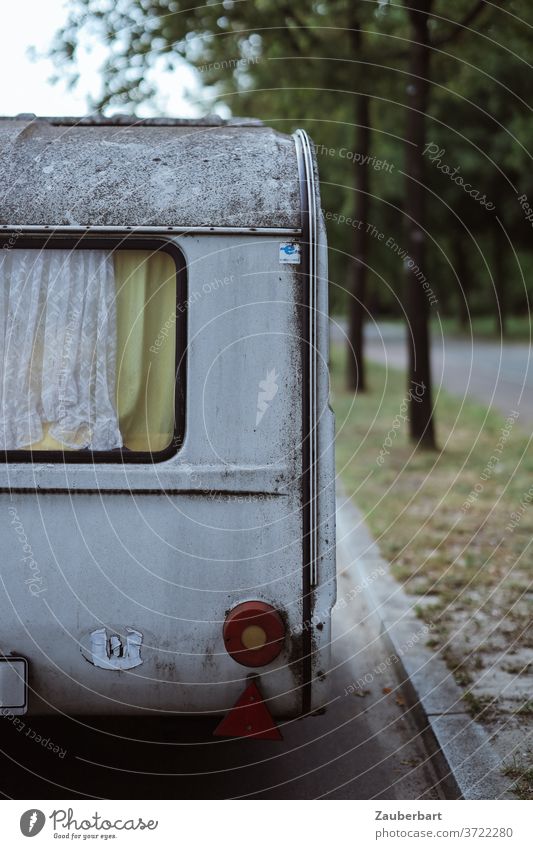 Alter Wohnwagen mit Fenster und Gardine am Straßenrand gelb alt verwittert Urlaub Camping Vanlife abstellen abgestellt Ferien & Urlaub & Reisen Mobilität retro