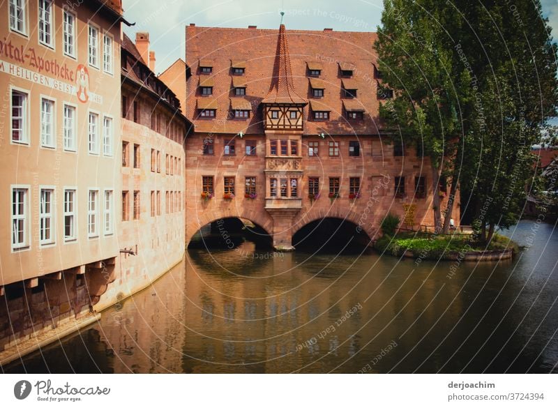 Spital Apotheke  Nürnberg , Architektur im alten Stil . Ein Fluß durchfließt das Gebäude. Daneben steht ein Baum. Franken Außenaufnahme Farbfoto historisch Haus