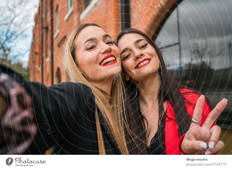 Zwei junge Freunde, die sich im Freien vergnügen. Porträt zwei Selfie heiter Straße Erwachsener Treffpunkt Mädchen reisen Frau urban Freizeit Freude Stil cool