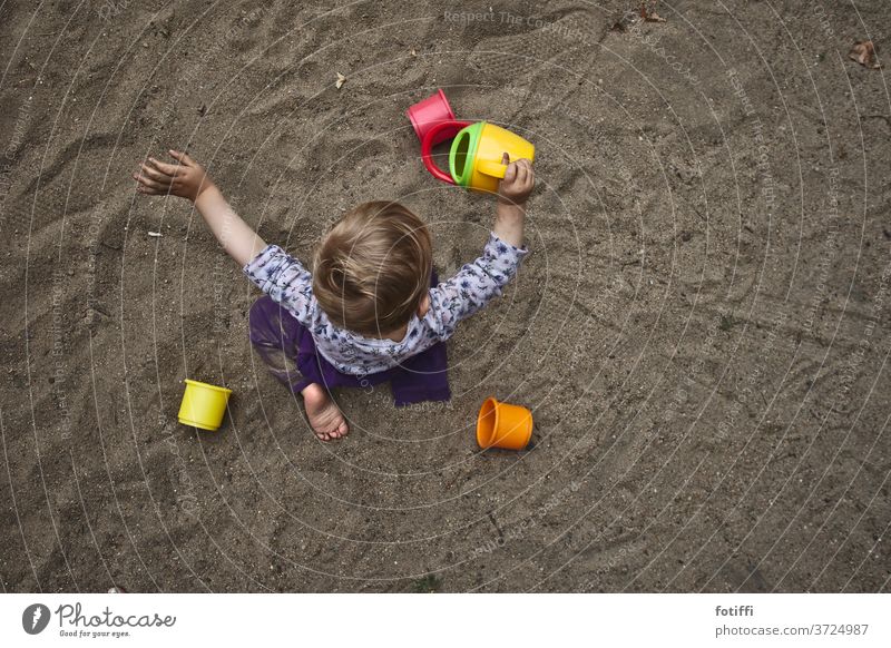 Sandkind Sandspielzeug Kind Vogelperspektive Spielen Spielzeug Sandkasten versunken Kindheit rieseln Außenaufnahme Spielplatz Kinderspiel Kleinkind Tag