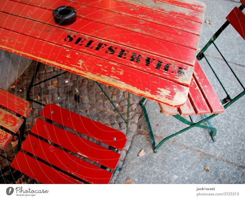 bediene dich selbst Tisch Bar Gastronomie Schriftzeichen rot Klappstuhl Abnutzung Klapptisch Aschenbecher Hinweis Holzstuhl gebraucht Englisch Großbuchstabe