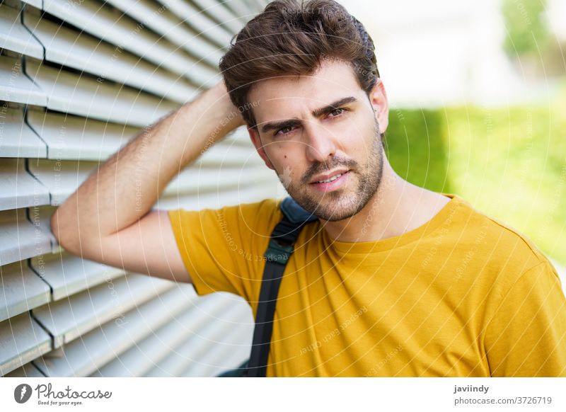 Junger Mann mit modernem Haarschnitt im städtischen Hintergrund männlich Frisur Schüler urban Lifestyle cool Person lässig Erwachsener jung im Freien Straße