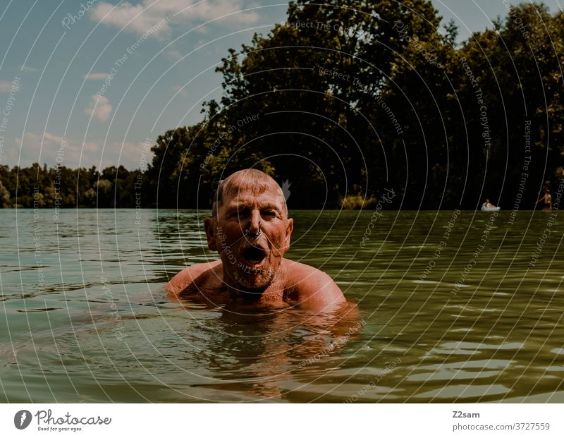 Rentner beim Schwimmen im See schwimmen freizeit rentner rente sommer see gewässer wasser sport bewegung nasenklammer sportlich braun alter mann portrait
