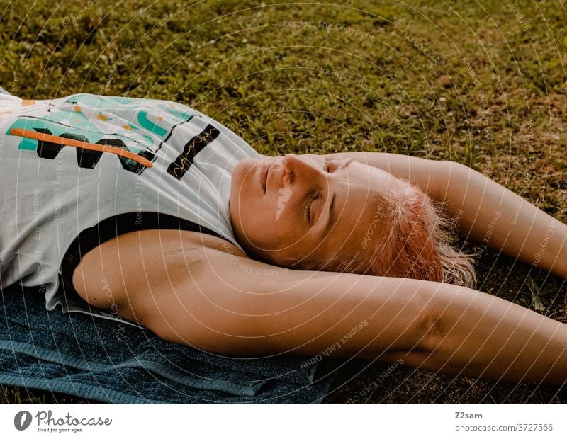 Junge Frau relaxt in der Wiese entspannung frau ausruhen ausgleich sommer sonne wiese natur liegen träumen schlafen erholung jung weiblich sportlich joga arme