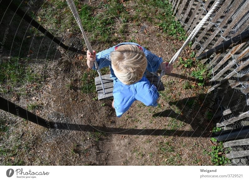 Kind auf dem Spielplatz Kindheit Junge Schaukel kita Kindergarten Grundschule aufwachsen Schwung Freizeit & Hobby schaukeln Außenaufnahme Freude Spielen Mensch