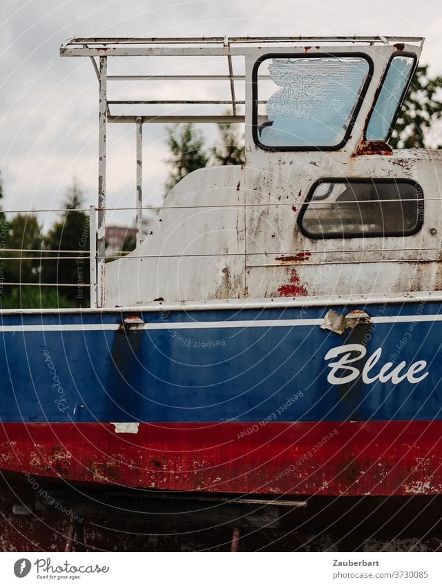 Blue - Seitenansicht und Brücke eines alten Motorboots in rot und Blau Boot blau weiß Heck Rost verrostet Lager Bootslager Bock aufgebockt Schiff