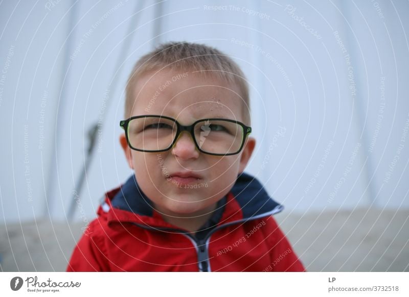 kleiner Junge mit Brille, der Gesichter macht Brillen zum Anschauen Religion & Glaube glückliches Kind Lächeln schön Optimismus Akzeptanz Erfahrung Vertrauen