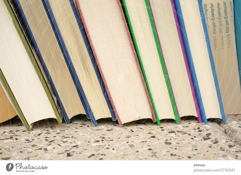 eine Reihe von Büchern unterschiedlicher Einbandfarbe mit einem gekennzeichneten Mängel-Exemplar Buch Mängelexemplar viele Wissen Information Literatur
