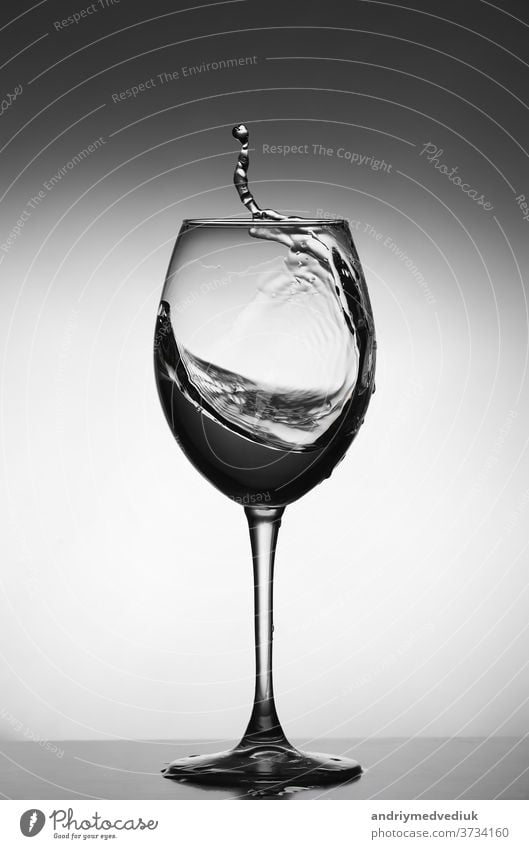 Weißweinspritzer auf grauem Hintergrund. Silhouette eines Glases. selektiver Fokus Wein trinken platschen weiß Restaurant Wasser Objekt Kristalle liquide