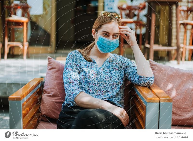 Junge Frau mit Maske draußen im Coffeeshop denkt 2020 Erwachsener schön Kaffee Kaukasier Großstadt Kaffeehaus Konzept Coronavirus covid-19 alltägliches Leben