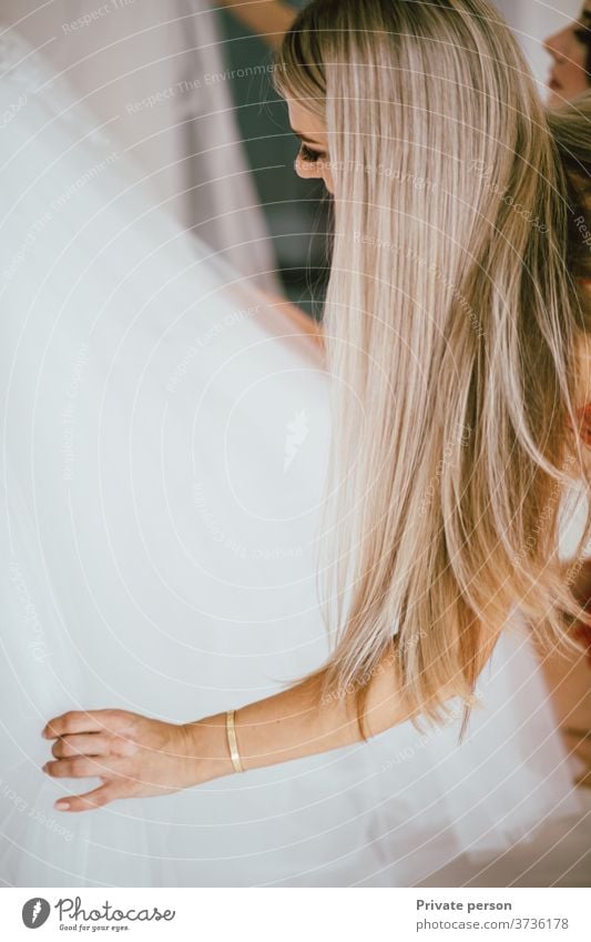 schöne junge Frau mit langen wallenden blonden Haaren untersucht weißes Brautkleid lange Haare Schönheit Mode-Modell Junge Frauen blondes Haar weißes Kleid