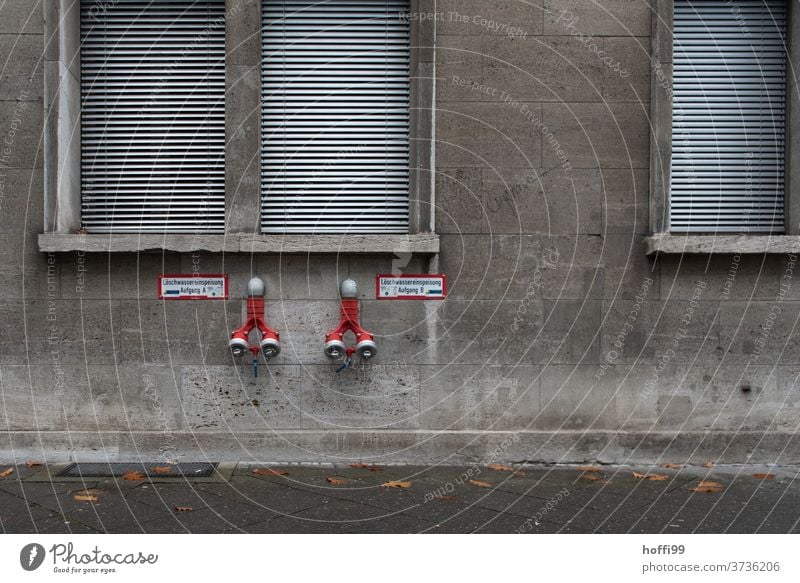zwei Hydranten an alter dreckiger Wand eines Hauses mit verschlossenen Jalousien Wasserhydrant Feuerwehr löschen Brandschutz Tristesse Altstadt Notfall