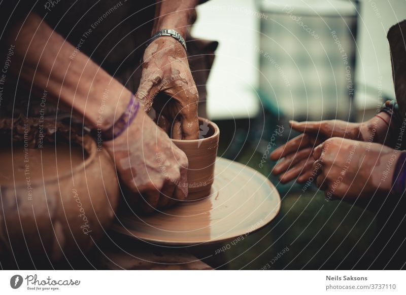 Nahaufnahme der Hände eines Töpfers und seines Schülers beim Töpfern lernen Töpferwaren Ton Rad Handwerk Topf Kunst Keramik Arbeit Basteln Fähigkeit