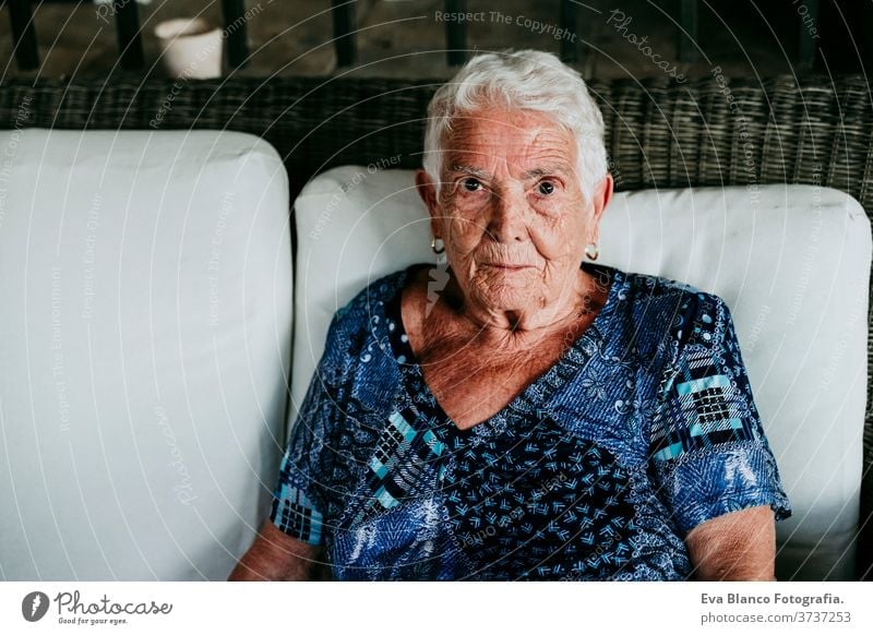 Porträt einer alten Dame in den 80er Jahren, die entspannt zu Hause sitzt. Frau älter heimwärts garrotte weiße Haare graue Haare mental Einsamkeit nachdenklich