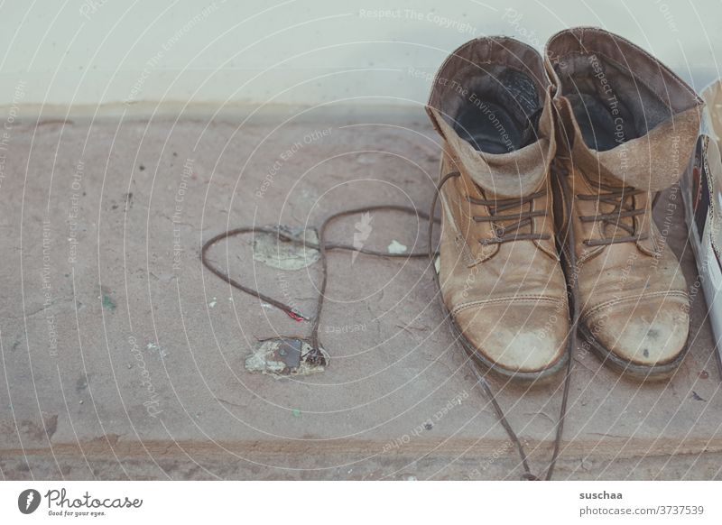 alte schuhe stehen auf einem fenstersims zum mitnehmen Schuhe Schnürschuhe gebraucht second hand Abnutzung zum verschenken Schnürsenkel Schnürstiefel Brauntöne