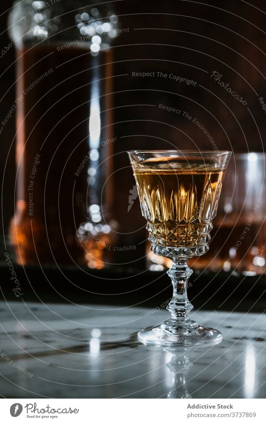 Glas mit alkoholischem Getränk auf Marmortisch Whiskey Bar Alkohol trinken Flasche dienen Abfertigungsschalter Schnaps Erfrischung Tisch Pub durchsichtig modern